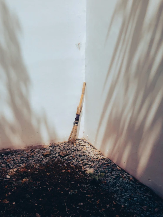 a wall with a shadow cast on it, and a tennis racquet leaning up against the wall