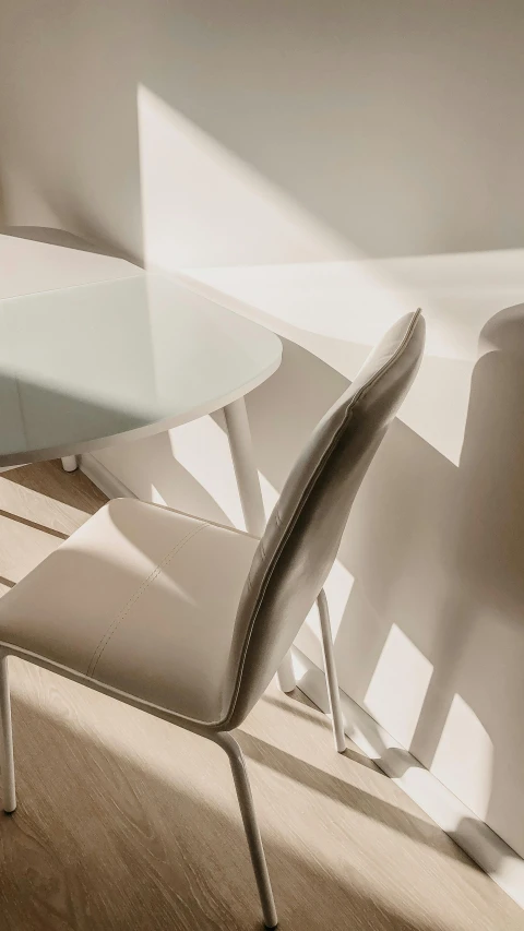 a white table and two chairs in a room, inspired by Zaha Hadid, trending on pexels, detail texture, sun lit, archviz, round-cropped