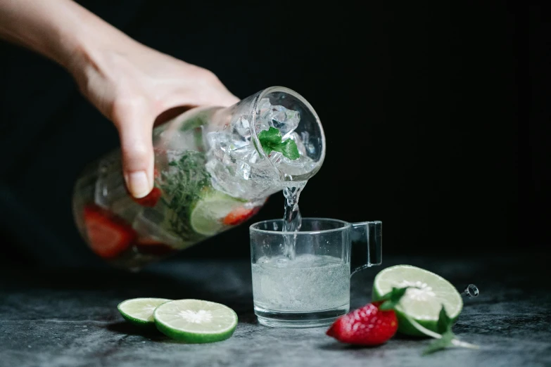 a person pours liquid into a clear glass