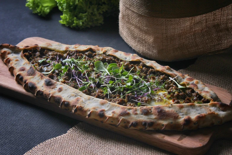 a pizza sitting on top of a wooden cutting board, hurufiyya, herbs, canoe, middle eastern details, brown