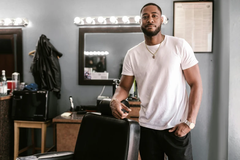 a man standing next to a chair in a barber shop, jaylen brown, lean man with light tan skin, high quality upload, thumbnail