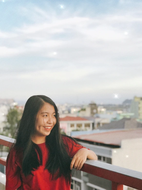 a woman in a red dress standing on a balcony, a picture, inspired by Ruth Jên, pexels contest winner, 🤤 girl portrait, student, cindy avelino, friendly smile