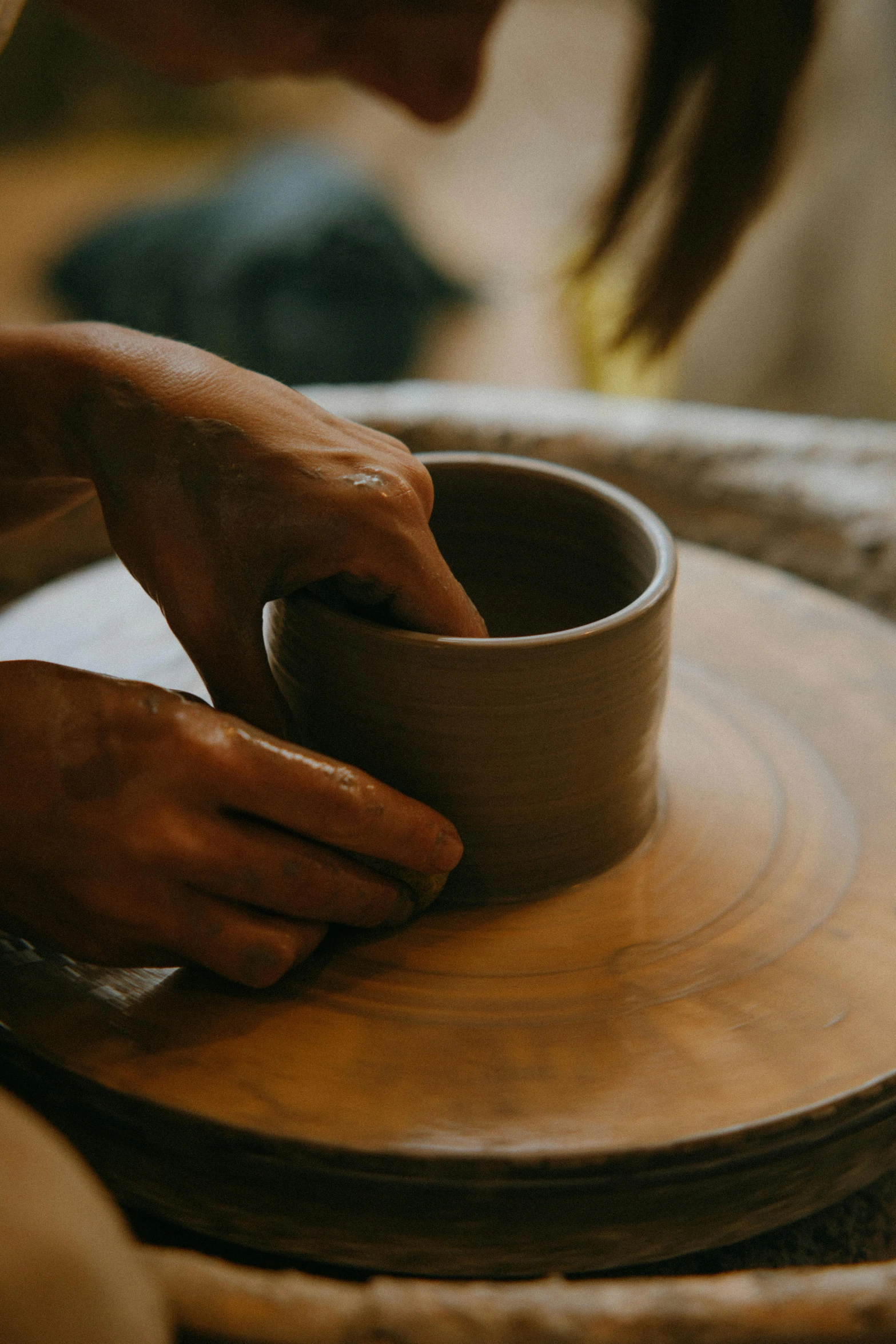 a woman is making a bowl on a potter's wheel, a still life, inspired by Hendrik Gerritsz Pot, trending on unsplash, ochre, made of glazed, coffee cup, low detail