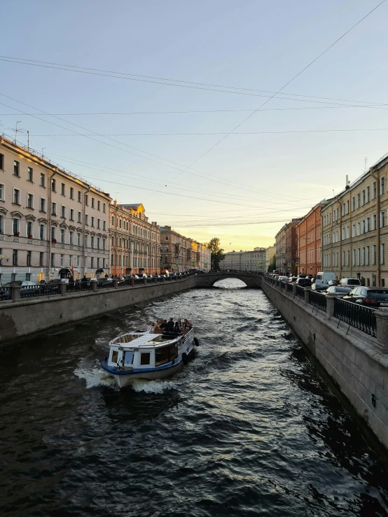 a boat traveling down a river next to tall buildings, saint petersburg, promo image, early evening, multiple stories