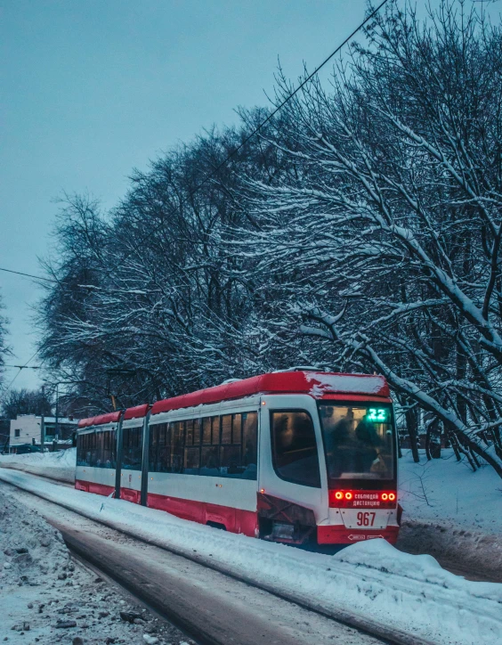 a red and white train in snowy weather