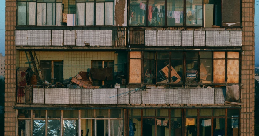 a very tall building with a bunch of windows, an album cover, inspired by Elsa Bleda, pexels contest winner, brutalism, damaged japanese clothes, shanty town, apartment, hong soonsang