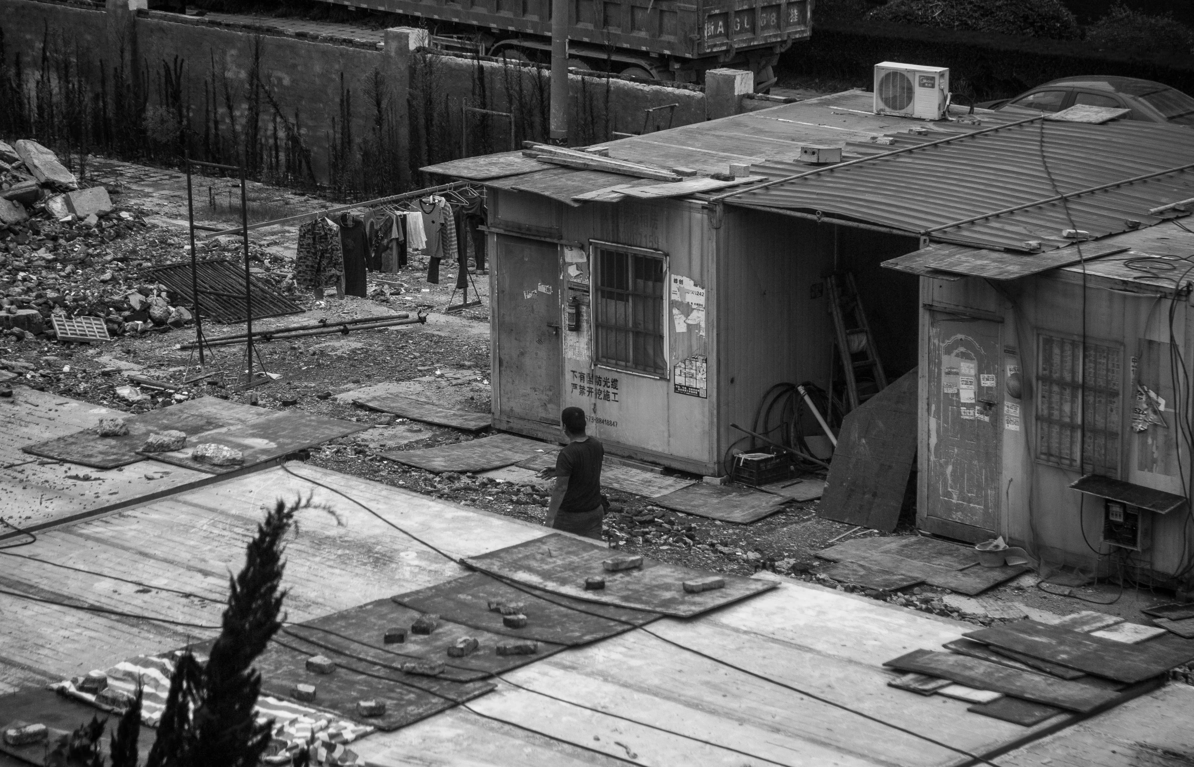 a man stands in front of a shack