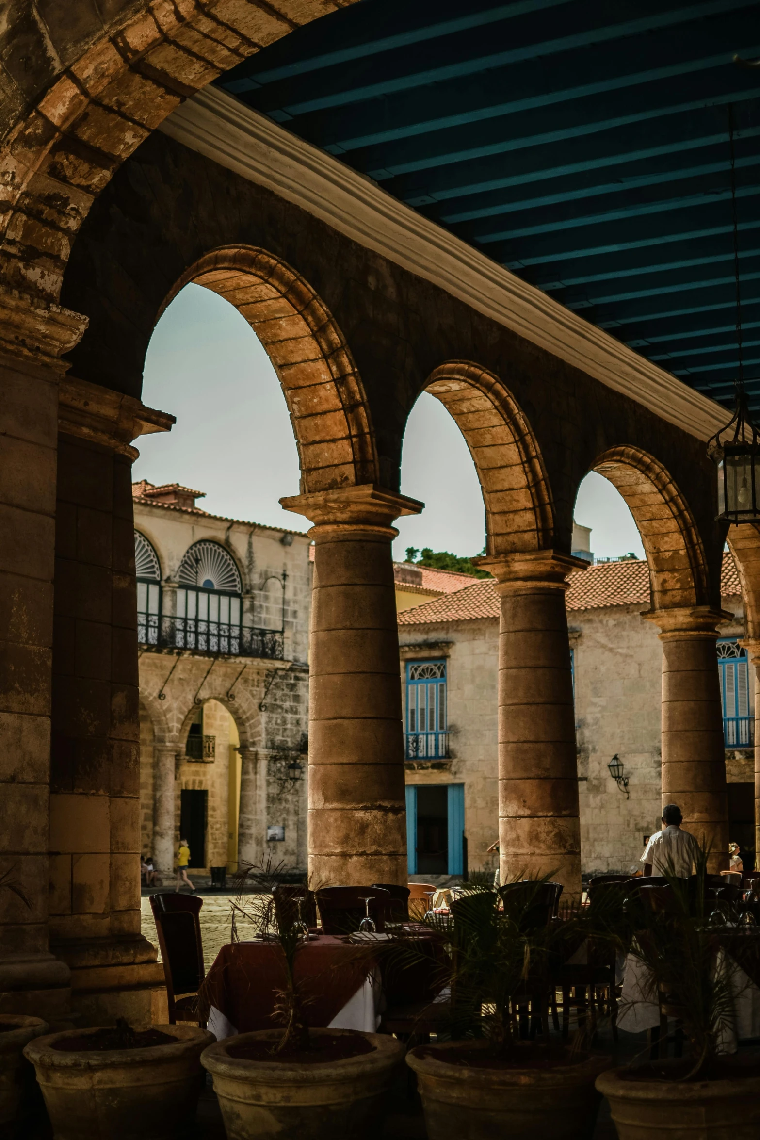 an indoor patio with large stone arches and potted plants