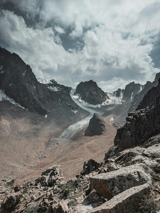 a mountain side with some rocks and water