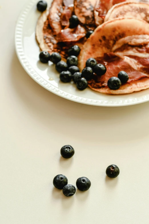 three pancakes with blueberries on a plate