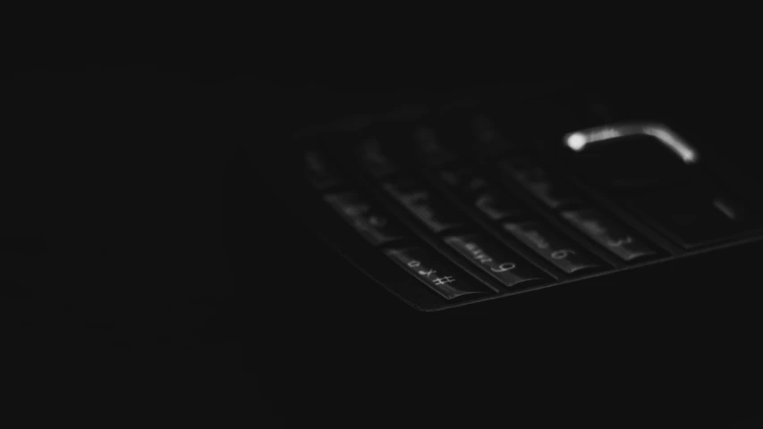 a close up of a cell phone in the dark, a black and white photo, by Emma Andijewska, unsplash, digital art, keyboard, black main color, jet - black skin, minimalistic