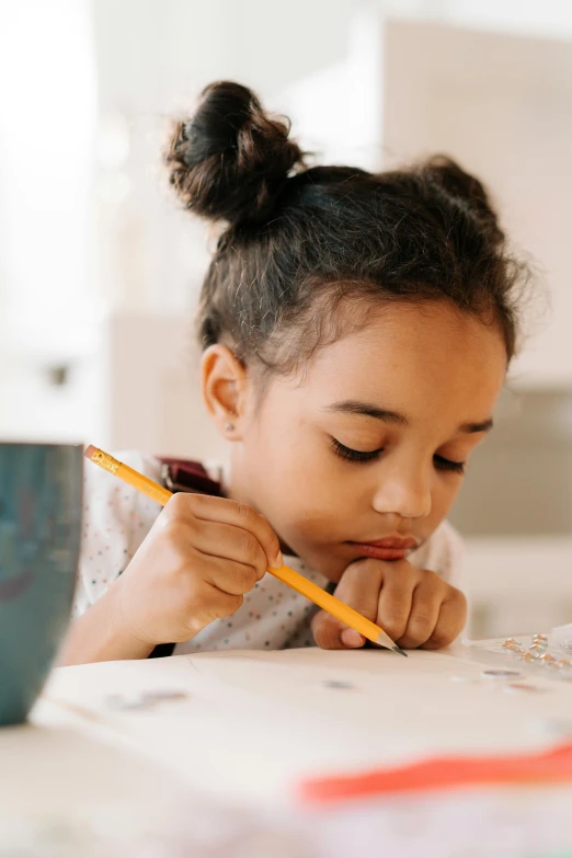 a little girl sitting at a table with a pencil in her hand, pexels contest winner, varying ethnicities, profile pic, splash image, 15081959 21121991 01012000 4k