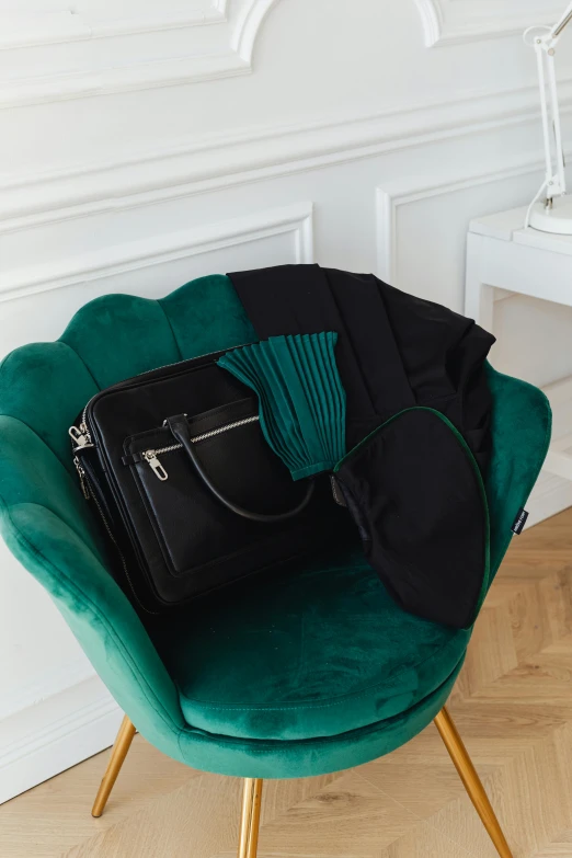 a black purse sitting on top of a green chair