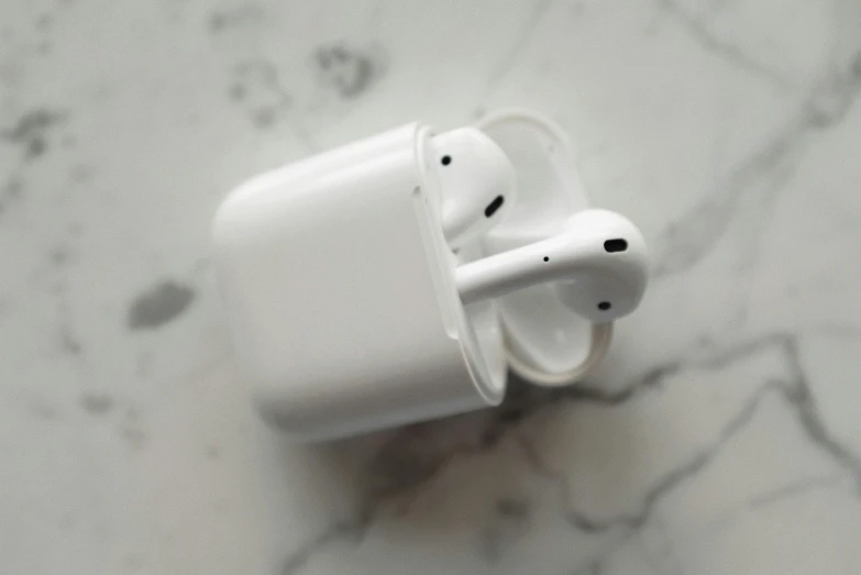 an apple airpods sitting on a marble surface, by Carey Morris, trending on pexels, pipes, photo taken in 2018, square, charging plug in the chest