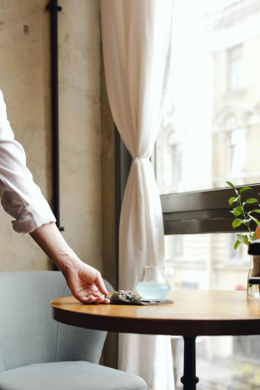 a person reaching for a drink at a table