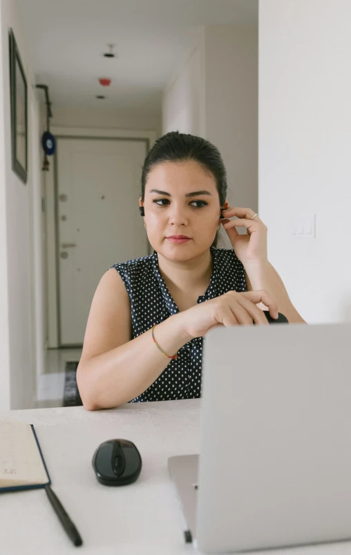 a woman sitting in front of a laptop computer, by Alejandro Obregón, pexels, looking serious, low quality photo, avatar image, image