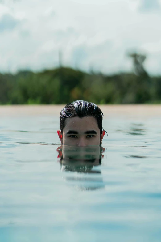 a man swimming in a pool with trees in the background, an album cover, unsplash, zayn malik, bali, headshot, beaches