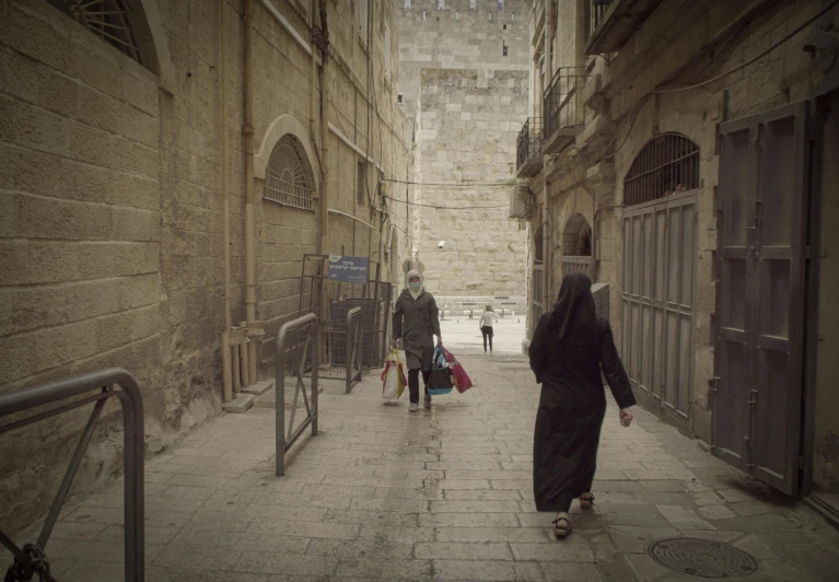 a group of people walking down a narrow street, pexels contest winner, les nabis, jerusalem, woman in black robes, old color photograph, ( conceptual art )