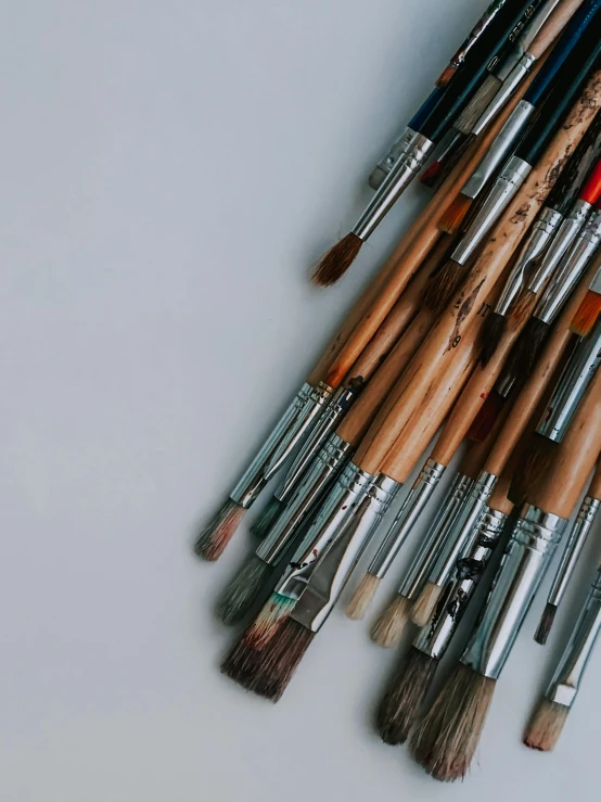 a bunch of paint brushes sitting on top of a table, a minimalist painting, by Ivana Kobilca, trending on unsplash, close up. macro. hyper realistic, set against a white background, ilustration, on canvas