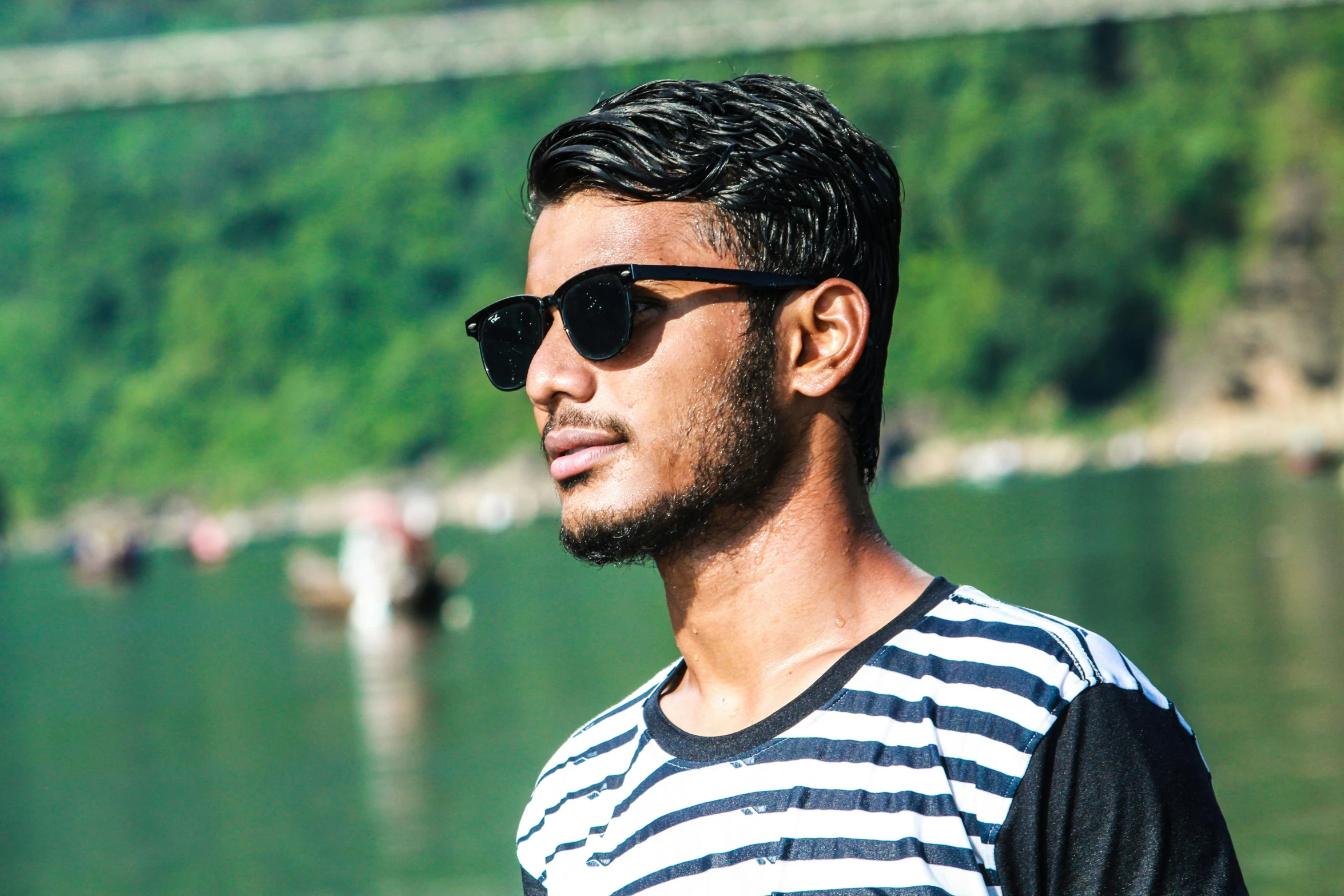 a man standing in front of a body of water, a picture, pexels contest winner, hurufiyya, in sun glasses, avatar image, assamese, headshot profile picture