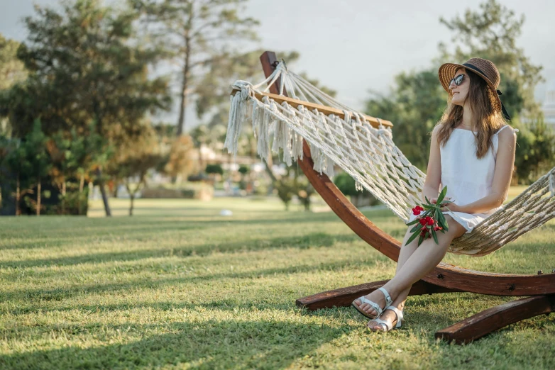 a girl in white dress sitting on a hammock