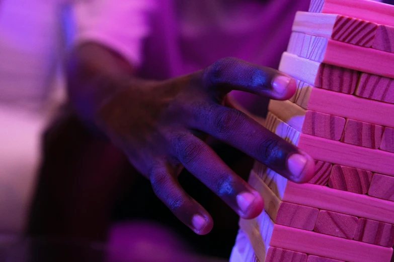 a person holding a block of bricks in his hand