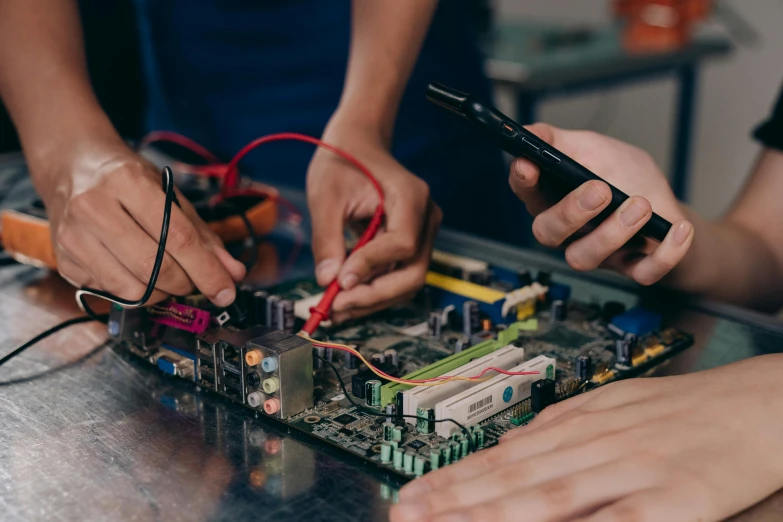 a group of people working on electronics on a table, by Gwen Barnard, pexels, teaser, old computer, idealised, student