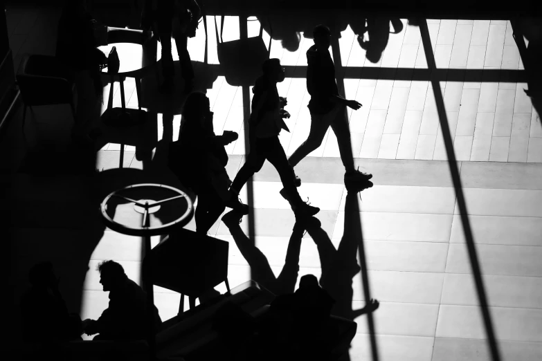 a group of people walking through a lobby, a black and white photo, by Matthias Weischer, pexels, silhouette!!!, black. airports, summer sunlight, high-angle