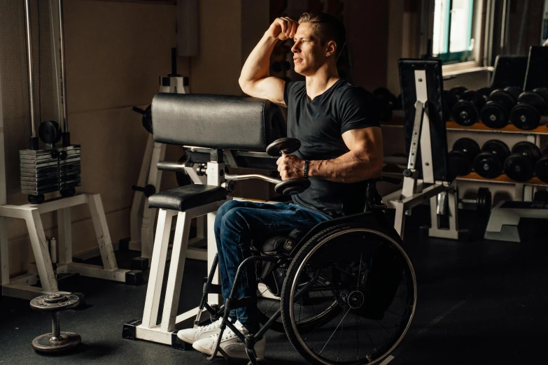 a man sitting in a wheelchair with his hand on his head