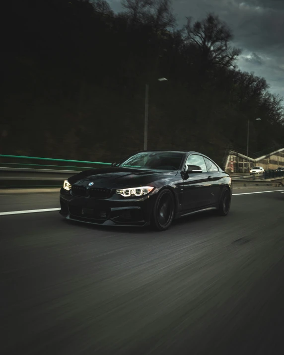 a black bmw is parked on a city street