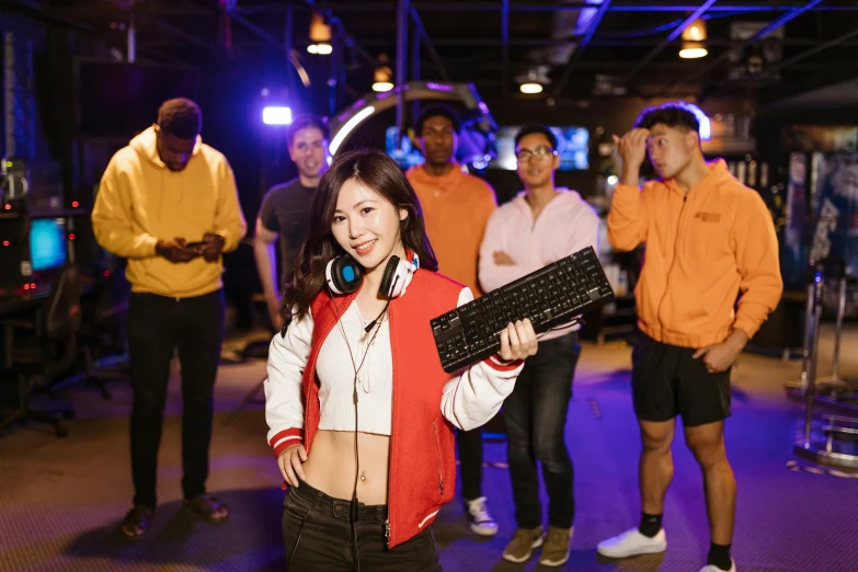 a woman holding a keyboard in front of a group of people, inspired by Jang Seung-eop, pexels contest winner, e-sport style, posing for a picture, 2 5 6 x 2 5 6 pixels, arcade