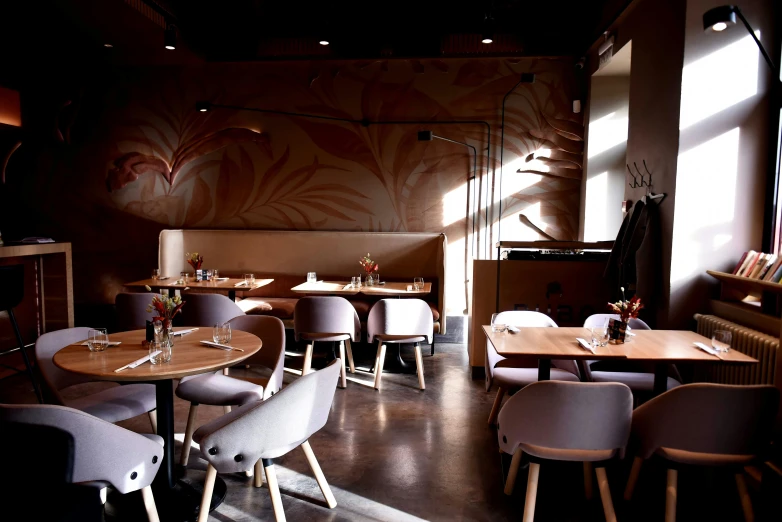 the interior of a restaurant with wood tables