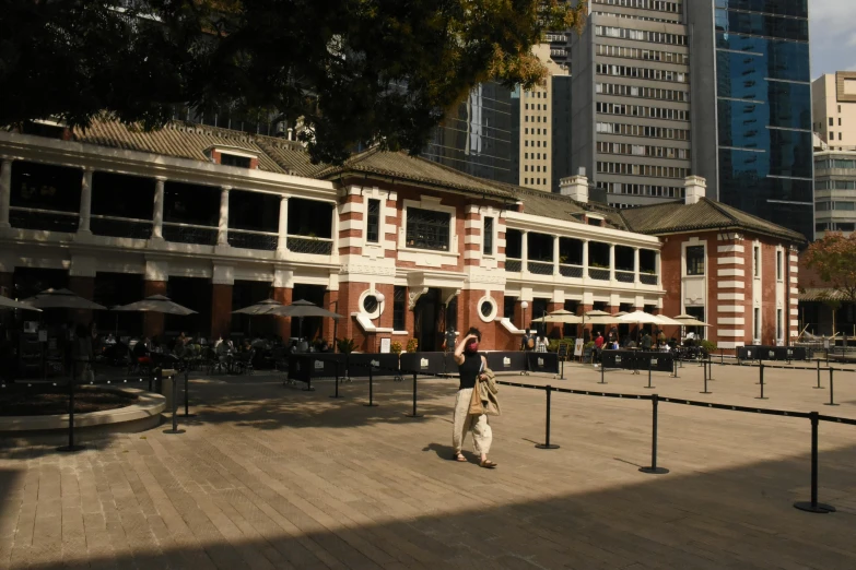 a man that is standing in front of a building, inspired by Shunkōsai Hokushū, pexels contest winner, of augean stables, long street, viewed from the harbor, rows of canteen in background