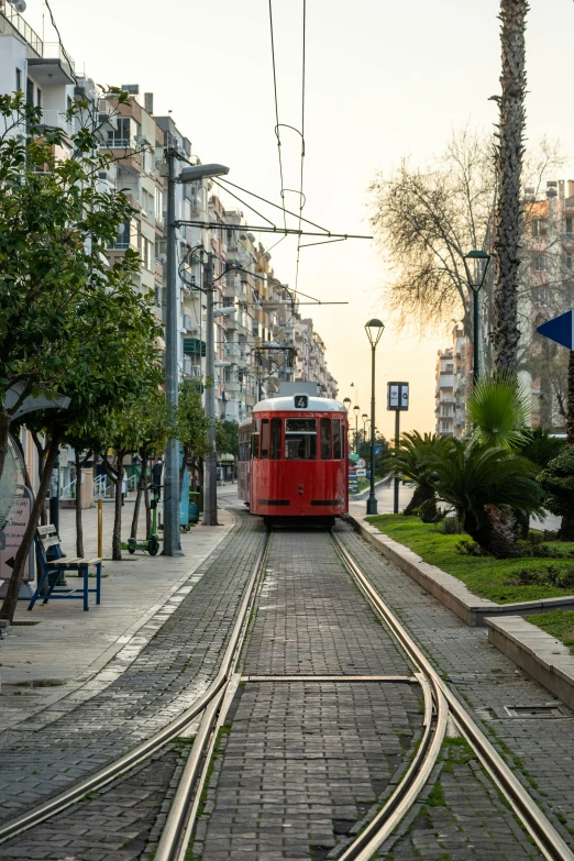 a red trolley car traveling through a city street