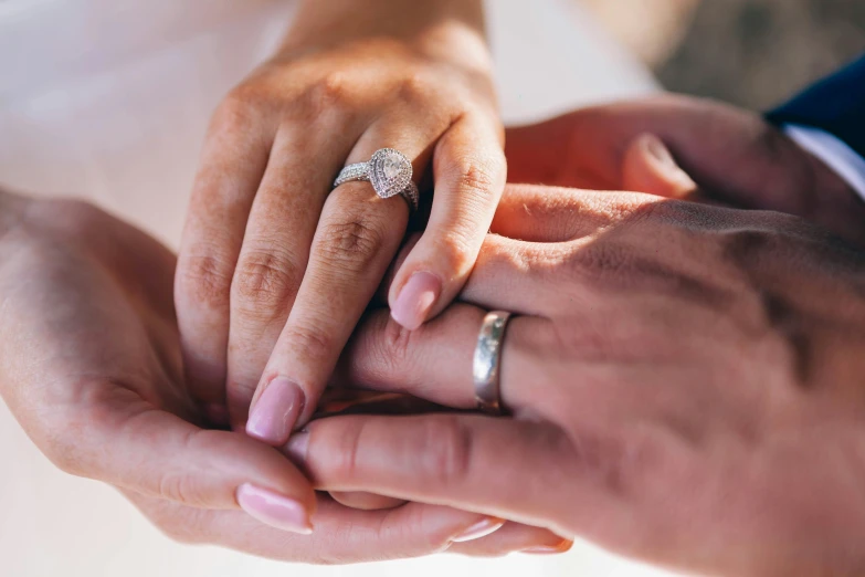 a close up of a person holding a wedding ring, pexels, husband wife and son, romantic lead, ad image, platinum jewellery