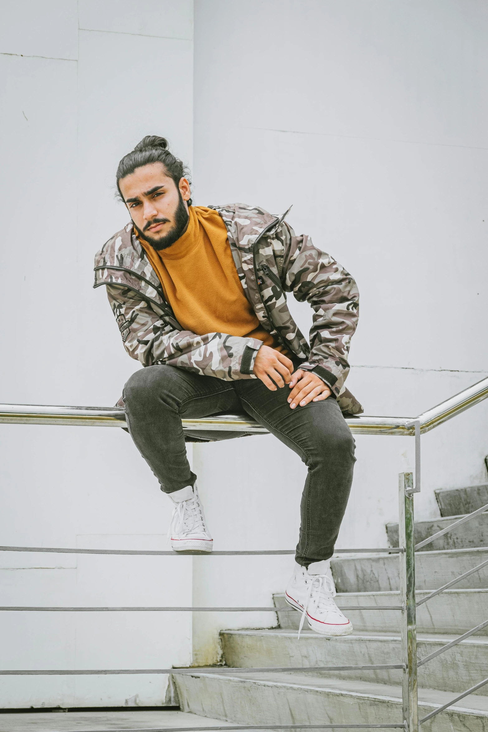 a man riding a skateboard down a flight of stairs, inspired by Ismail Acar, trending on pexels, wearing camo, thoughtful pose, model wears a puffer jacket, in front of white back drop