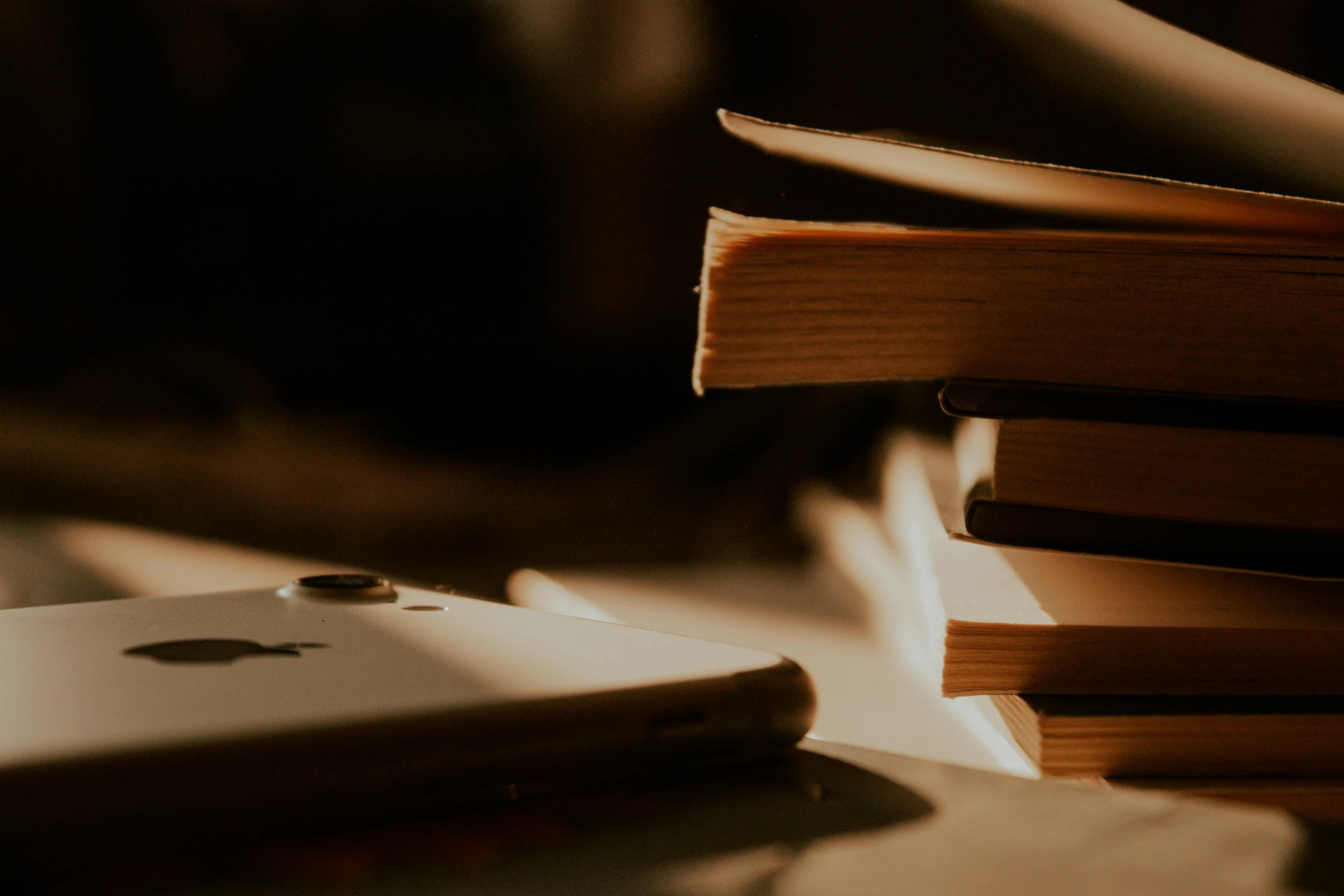 a stack of books sitting on top of a table next to a cell phone, trending on pexels, figuration libre, sepia, zoomed in, in the evening, thumbnail