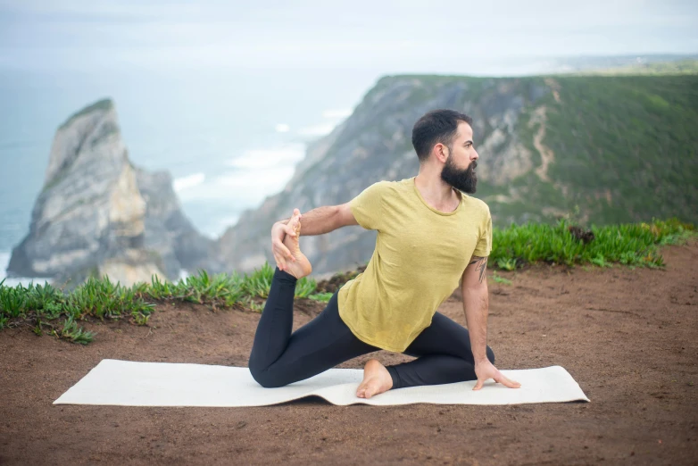a man in a yellow shirt is doing a yoga pose, pexels contest winner, arabesque, in a scenic background, lizard tail, avatar image, lachlan bailey