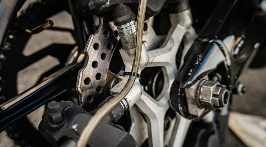 a close up of the front wheel of a motorcycle, connecting lines, leaking pistons, up close image, daniel richter