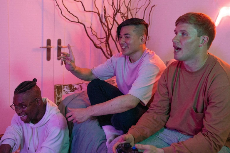 three men sitting on a couch playing a video game, pexels, conceptual art, brightly lit pink room, bisexual lighting, mix of ethnicities and genders, halo ark