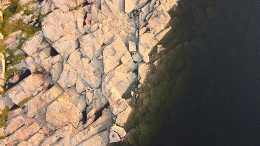 a bird's eye view of some rocks and water, pexels contest winner, photorealism, high polygon, light and dark, high angle vertical, teaser