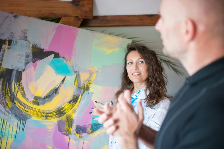 a man and a woman standing in front of a painting, pexels contest winner, arbeitsrat für kunst, profile image, calm feeling, liam brazier and nielly, in the center of the image