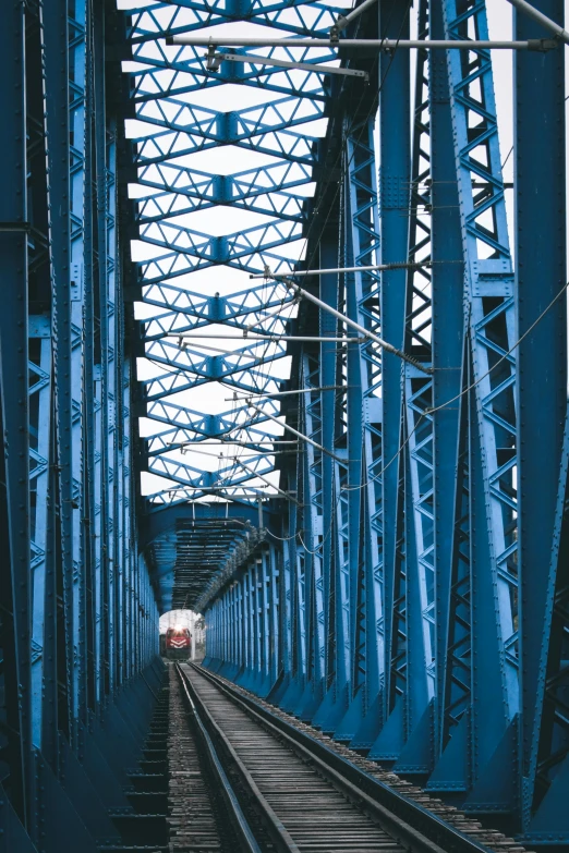 a train on a train track going over a bridge, blue walls, 2 5 6 x 2 5 6 pixels, view from inside, howrah bridge