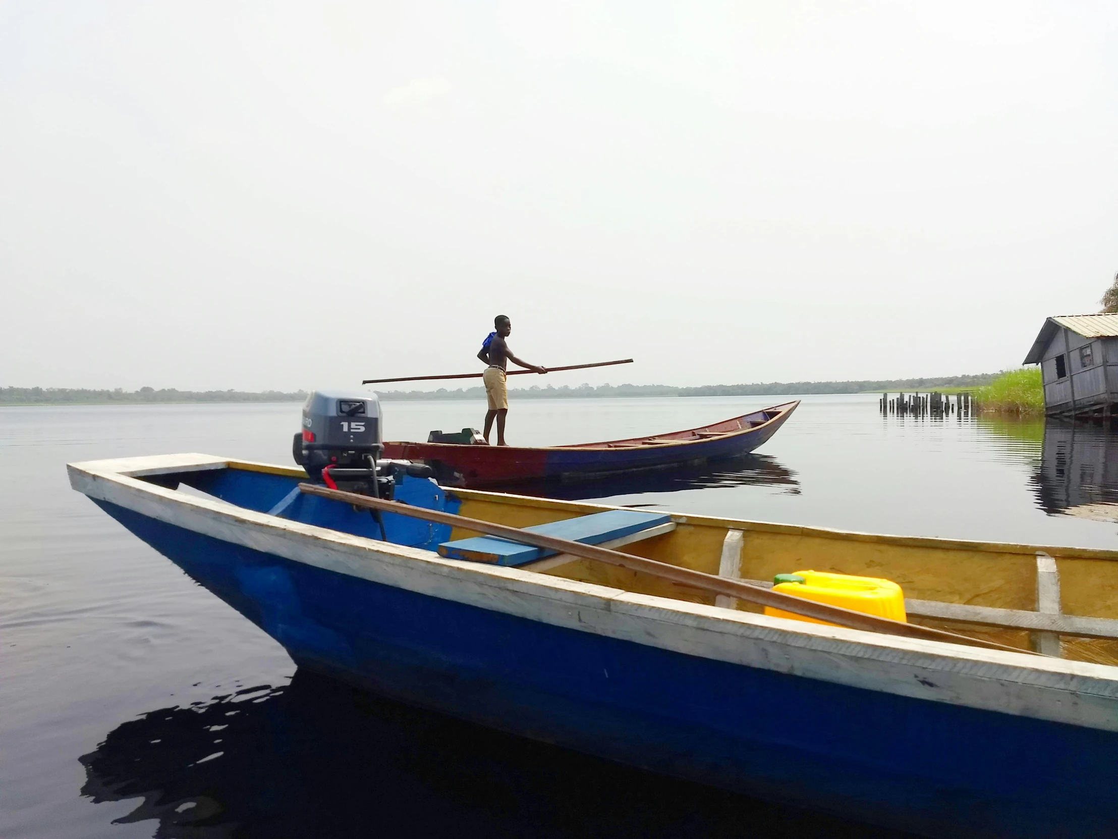 a couple of boats sitting on top of a lake, afar, profile image, fishing village, maintenance photo