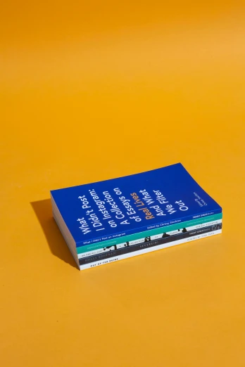 a blue book sitting on top of a yellow surface, trending on unsplash, fluxus, full color catalog print, four, series, pack