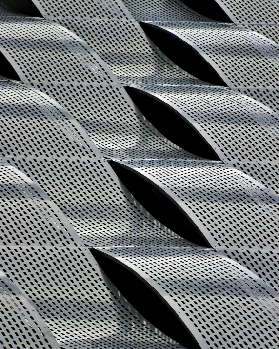 a close up of a metal structure with holes, inspired by Zaha Hadid, unsplash, op art, fish skin, chicago, leaf, shades of grey