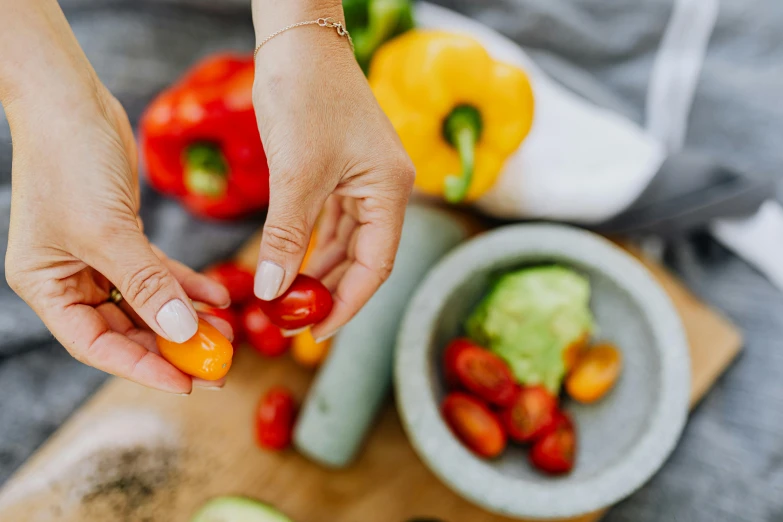 a close up of a person cutting vegetables on a cutting board, by Julia Pishtar, red+yellow colours, holding maracas, partially cupping her hands, avatar image