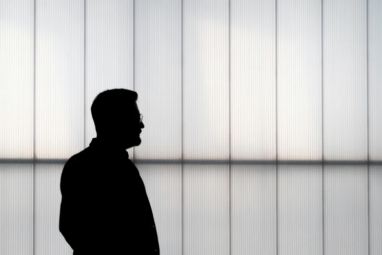 a silhouette of a man standing in front of a window, inspired by Ryoji Ikeda, minimalism, glass wall, portrait 4 / 3, fan favorite, olafur eliasson