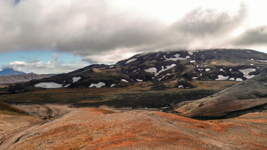 a mountain range is covered in snow and brown moss