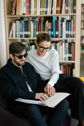 two men sitting on a couch in front of a bookshelf, by Nina Hamnett, trending on unsplash, academic art, with nerdy glasses and goatee, handsome girl, academic clothing, russian academic